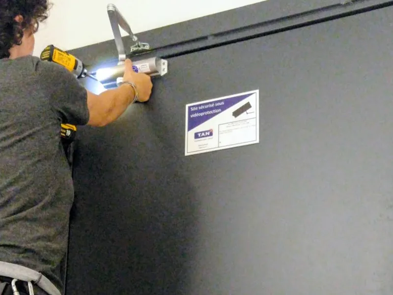 Pose d’un ferme-porte sur une porte métallique de garage